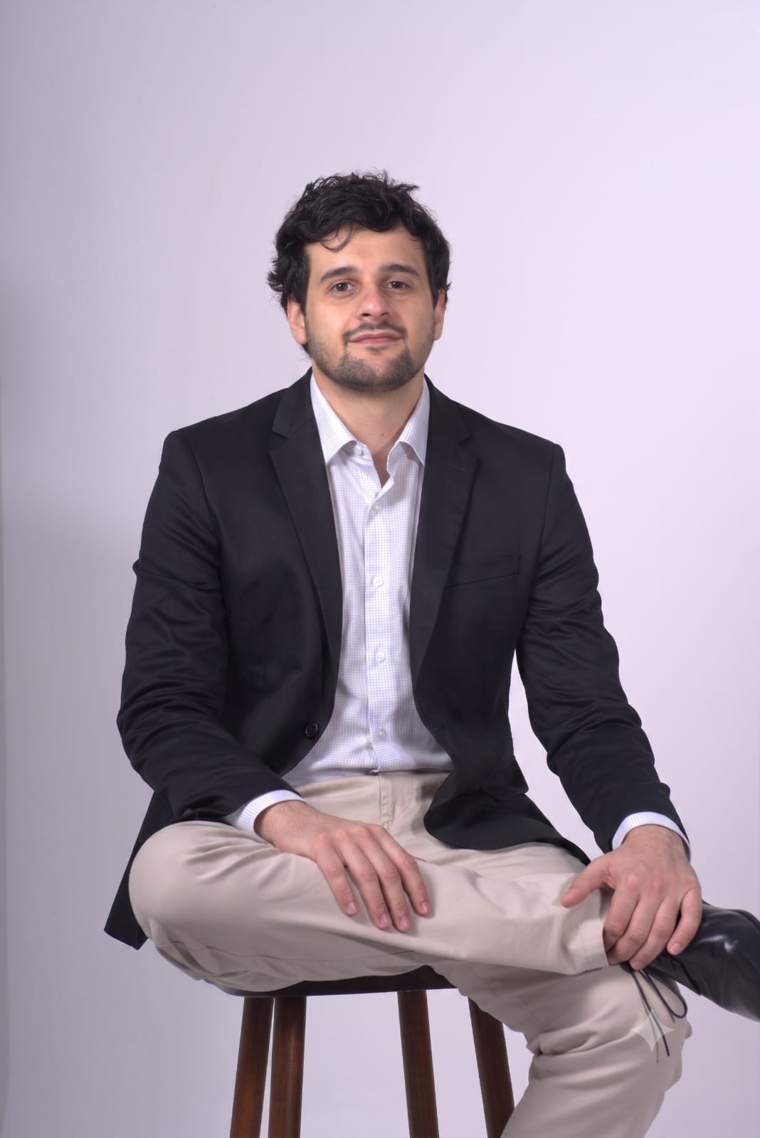 Victor Erides sentado, vestindo blazer escuro e camisa clara.